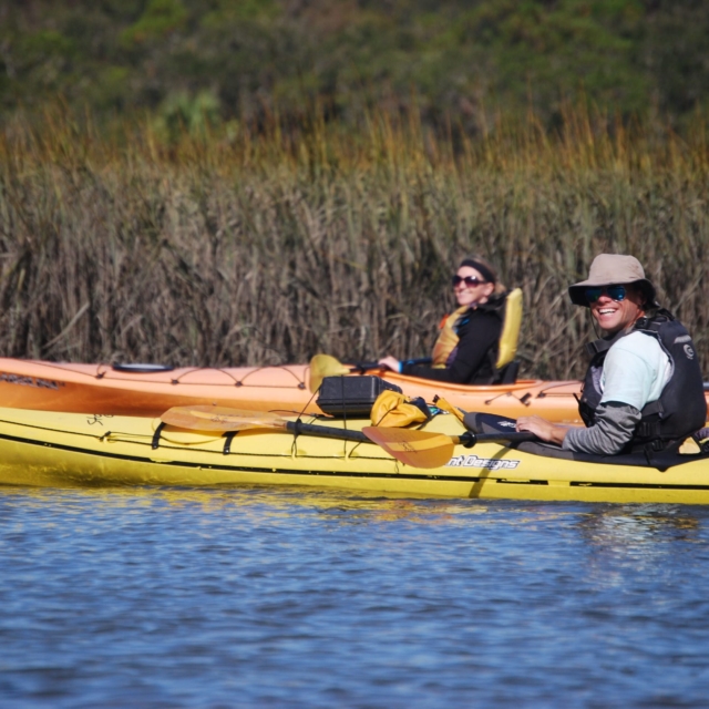 Guide and guest smiling on a kayaking tour.