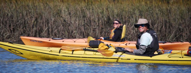 Guide and guest smiling on a kayaking tour.