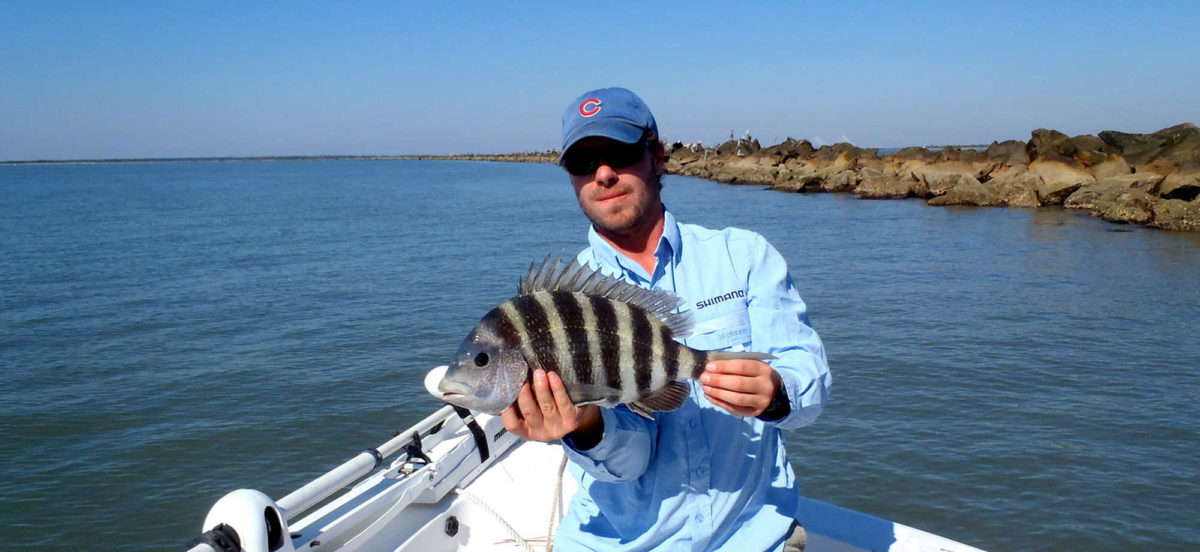 Man with a fish on the bow of the boat