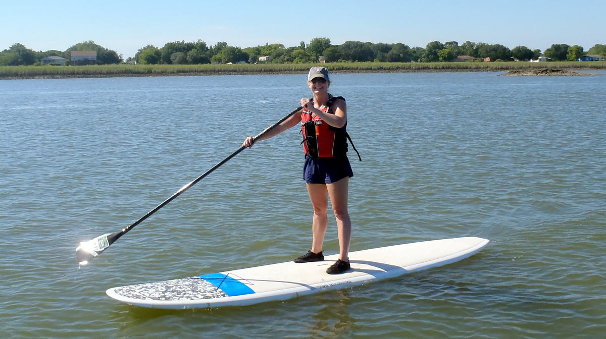 A woman paddleboarding on a 3 hour rental with COA.
